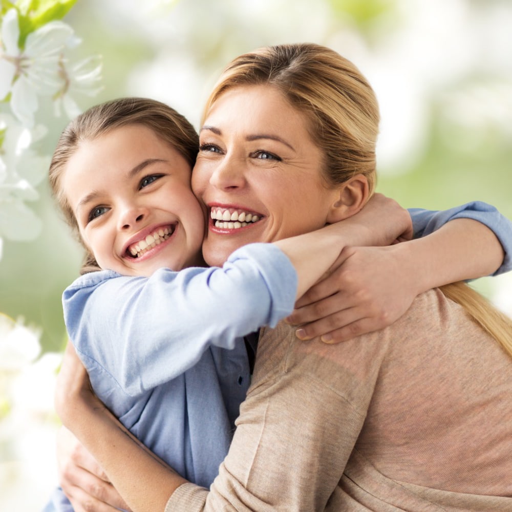 Mother and child hugging, illustrating lifelong orthodontic care and beautiful smiles.